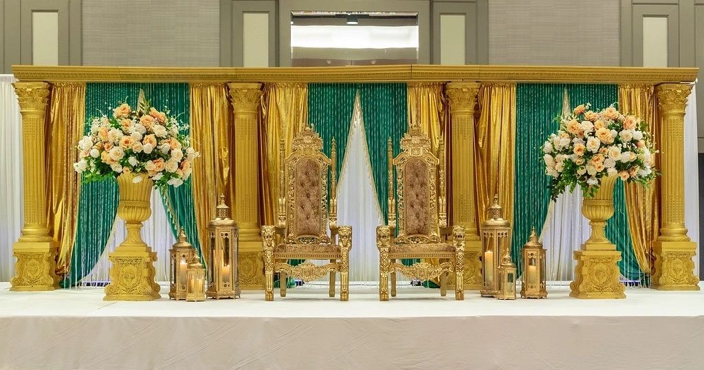 A gold and green stage with two chairs
