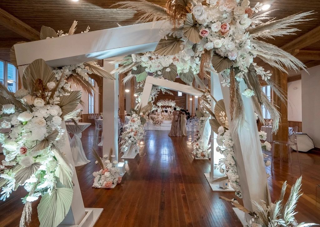 A long hallway with many white flowers and ribbons.