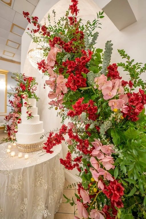 A wedding cake and flowers on the table.