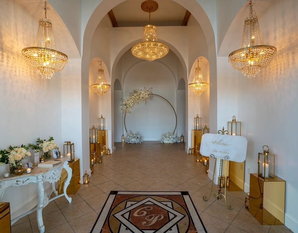 A hallway with many tables and chandeliers