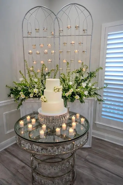 A cake on top of a glass table with candles.