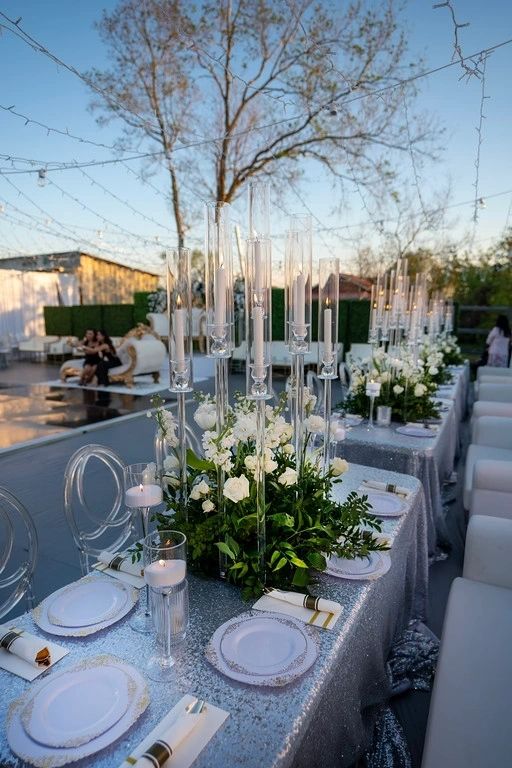 A table set up with white flowers and candles.