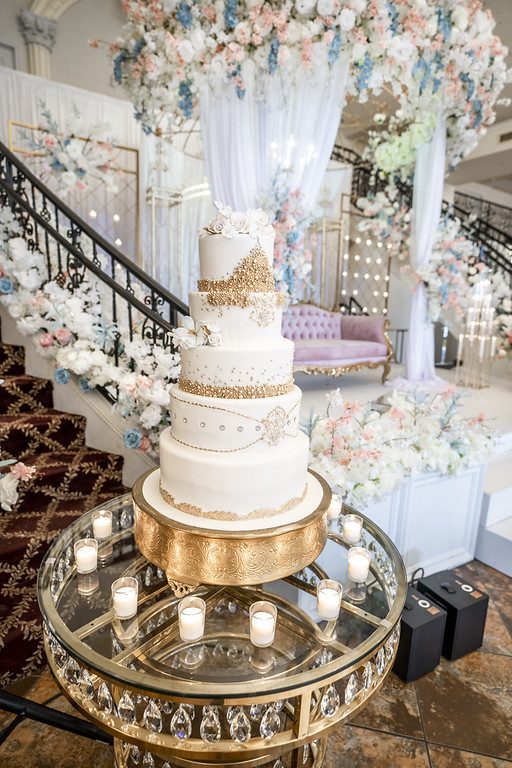 A wedding cake is on display in the middle of a room.