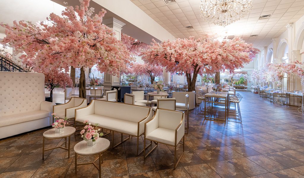 A room with many pink trees and white furniture