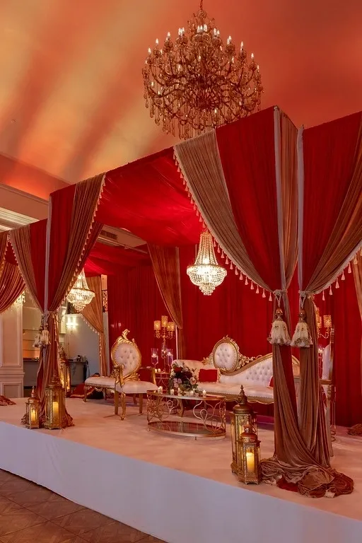 A room with red walls and curtains on the ceiling.