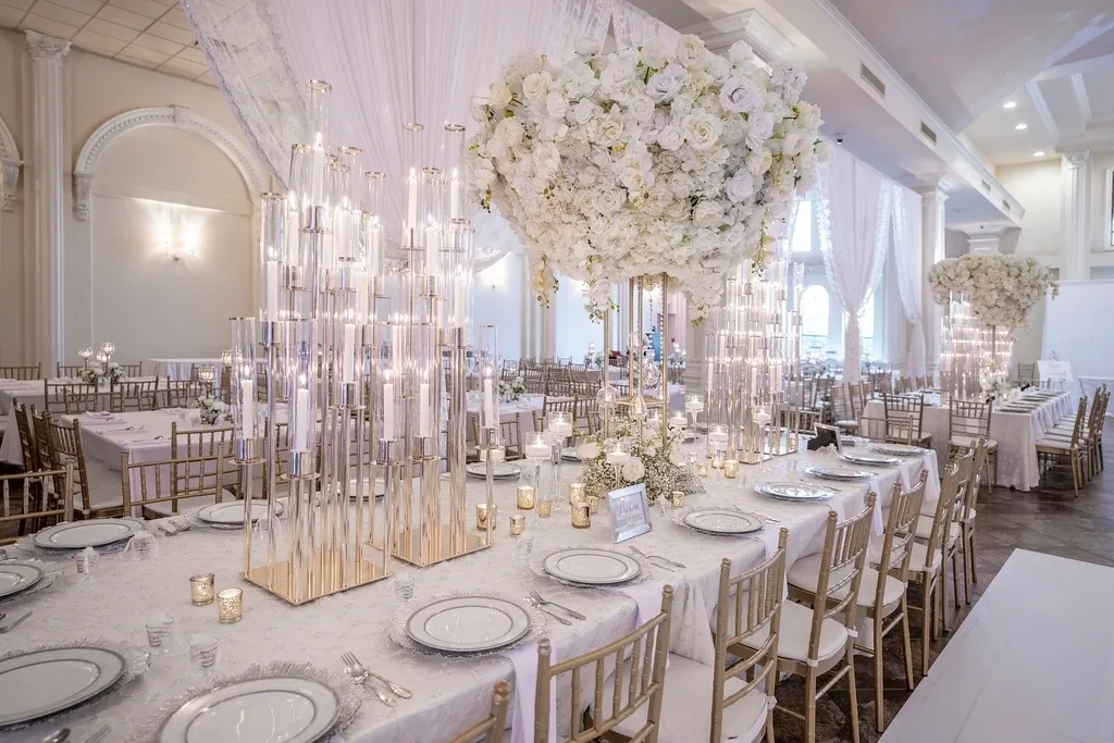 A long table with white flowers and candles.